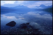 Rocks, peebles, and mountain reflections in lake McDonald. Glacier National Park, Montana, USA.