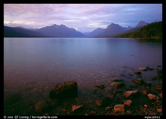 Rocks, Lake Mc Donald, and mountains at sunset. Glacier National Park, Montana, USA.