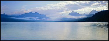 Serene lake with clouds hanging over mountains. Glacier National Park (Panoramic color)