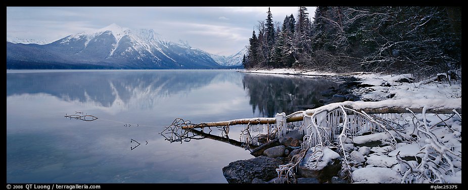 Lake, snowy shore, and mountains in winter. Glacier National Park (color)