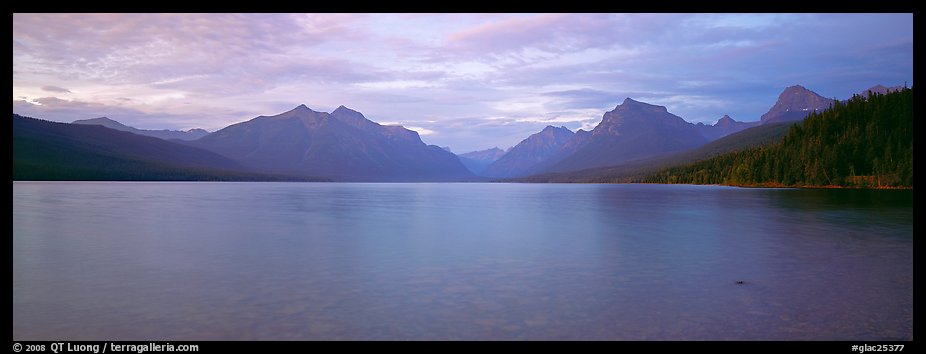 Mountains rising above calm lake in the evening. Glacier National Park, Montana, USA.