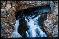 Water flows of opening in cliff face, Running Eagle Falls. Glacier National Park ( color)