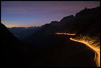 Going-to-the-Sun road at dusk with car lights. Glacier National Park, Montana, USA.