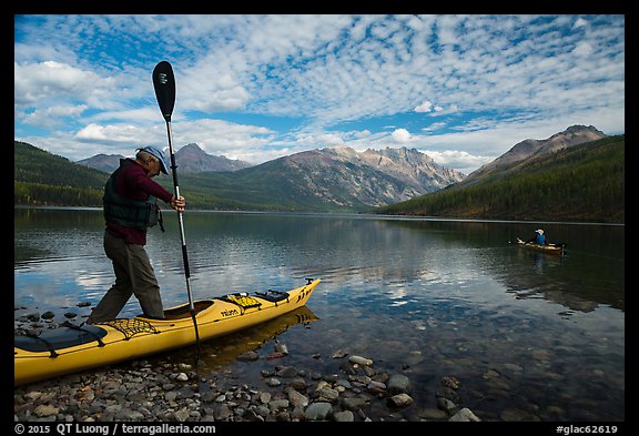 Kayaker steps into kayak, Kintla Lake. Glacier National Park (color)