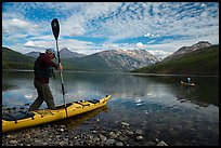 Kayaker steps into kayak, Kintla Lake. Glacier National Park ( color)