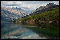 Kayaker paddling back to shore as clouds threaten, Kintla Lake. Glacier National Park ( color)