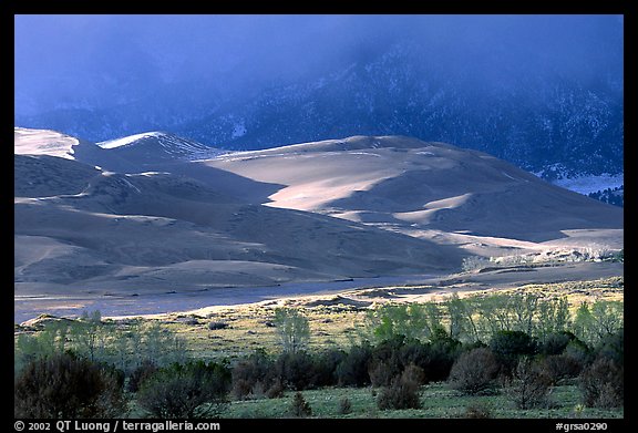 Storm light illuminates portions of the dune field. Great Sand Dunes National Park, Colorado, USA.