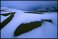 Patch of sand in snow-covered dunes. Great Sand Dunes National Park, Colorado, USA.