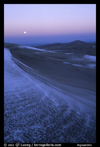 Dunes at dawn with snow and moon. Great Sand Dunes National Park, Colorado, USA.