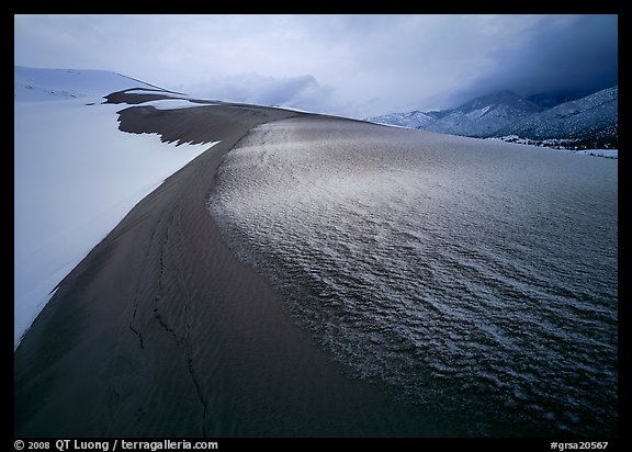 Zig-zag pattern of sand amongst Snow on the dunes. Great Sand Dunes National Park, Colorado, USA.