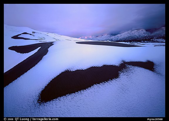 Patch of sand in snow-covered dunes. Great Sand Dunes National Park and Preserve, Colorado, USA.