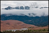 Dunes and Medano creek below snowy mountains. Great Sand Dunes National Park and Preserve, Colorado, USA.