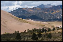 Sangre de Cristo range with bright patches of aspen above dunes. Great Sand Dunes National Park, Colorado, USA. (color)