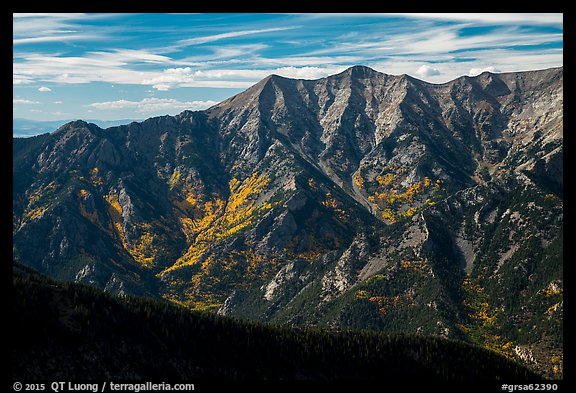 Rugged Sangre de Cristo mountains brightened by aspens in fall foliage. Great Sand Dunes National Park and Preserve, Colorado, USA.