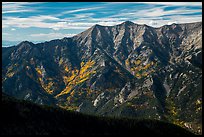 Rugged Sangre de Cristo mountains brightened by aspens in fall foliage. Great Sand Dunes National Park and Preserve, Colorado, USA.