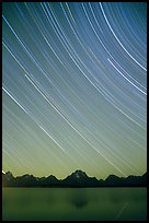 Star trails on Teton range above Jackson lake, dusk. Grand Teton National Park, Wyoming, USA.