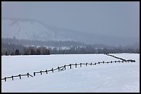 Wooden fence, snow-covered flat, hills in winter. Grand Teton National Park, Wyoming, USA.