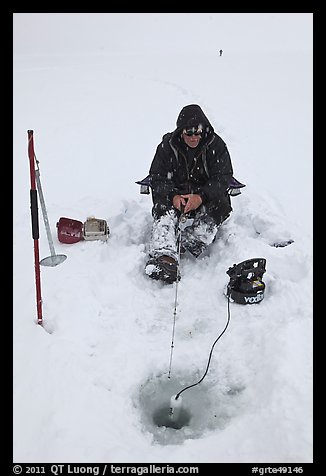 Man ice fishing with radar on Jackson Lake. Grand Teton National Park, Wyoming, USA.