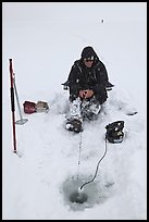 Man ice fishing with radar on Jackson Lake. Grand Teton National Park, Wyoming, USA. (color)