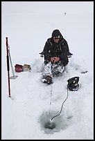 Man ice fishing with radar on Jackson Lake. Grand Teton National Park, Wyoming, USA.