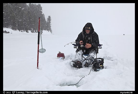 Ice fisherman in white-out, Jackson Lake. Grand Teton National Park, Wyoming, USA.