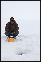 Ice fishing during a snow storm, Jackson Lake. Grand Teton National Park, Wyoming, USA.