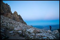 Mountaineer jumps on boulder at Lower Saddle,dusk. Grand Teton National Park ( color)