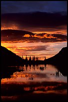 Sunrise with colorful clouds reflected on a pond in Horseshoe park. Rocky Mountain National Park, Colorado, USA.