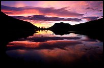 Colorful sunrise clouds reflected in a pond in Horseshoe park. Rocky Mountain National Park, Colorado, USA.