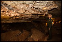 Ranger pointing at speleotherm in large cave room. Wind Cave National Park, South Dakota, USA. (color)