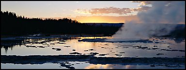 Steam rising in geyser pool at sunset. Yellowstone National Park, Wyoming, USA.