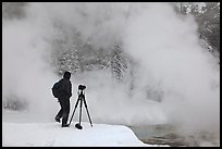 Photographer standing next to hot springs. Yellowstone National Park, Wyoming, USA.