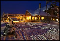 Snowmobiles parked next to Old Faithful Snow Lodge at night. Yellowstone National Park, Wyoming, USA.