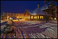 Snowmobiles parked next to Old Faithful Snow Lodge at night. Yellowstone National Park, Wyoming, USA. (color)