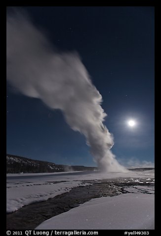 Night view of Old Faithful Geyser in winter with full moon. Yellowstone National Park, Wyoming, USA.