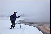 Skier at the edge of thermal pool. Yellowstone National Park, Wyoming, USA.