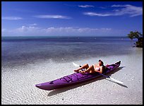 Woman reclining in kayak on shallow waters,  Elliott Key. Biscayne National Park, Florida, USA.