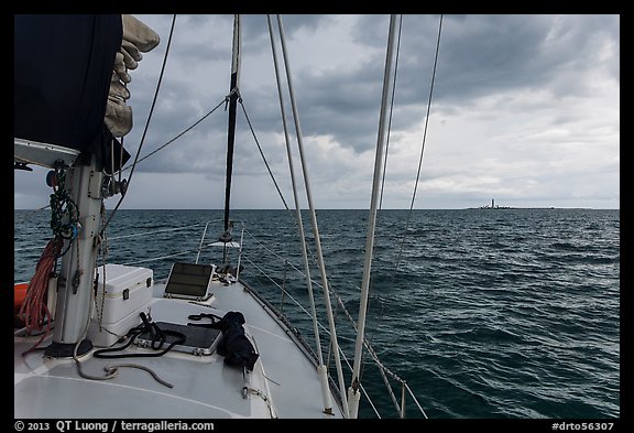 Loggerhead lighthouse seen from sailboat under dark skies. Dry Tortugas National Park, Florida, USA.