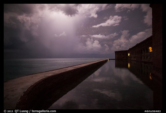 Fort Jefferson seawall at night with sky lit by tropical storm. Dry Tortugas National Park, Florida, USA.