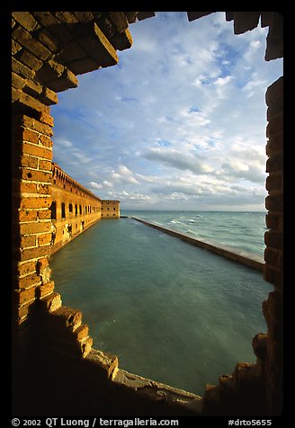 Fort Jefferson seawall and moat, framed by a crumpling embrasures, late afternoon. Dry Tortugas National Park, Florida, USA.