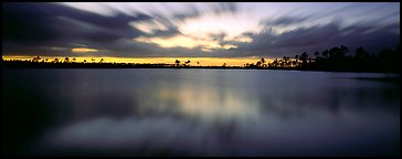 Dark clouds in motion at sunset over lake. Everglades  National Park (Panoramic color)