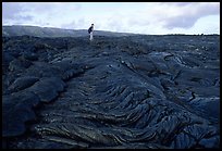 Hiker on hardened lava flow at the end of Chain of Craters road. Hawaii Volcanoes National Park, Hawaii, USA.