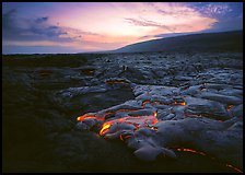 Volcanic landscape with molten lava flow and red spots at sunset. Hawaii Volcanoes National Park, Hawaii, USA. (color)