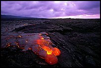 Flowing lava and rain clouds at dawn. Hawaii Volcanoes National Park, Hawaii, USA.