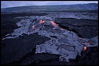 Live hot lava flows over hardened lava. Hawaii Volcanoes National Park, Hawaii, USA.