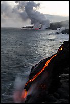 Bright molten lava flows into the Pacific Ocean, plume in background. Hawaii Volcanoes National Park, Hawaii, USA. (color)