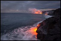 Streams of hot lava flow into the Pacific Ocean at the shore of erupting Kilauea volcano. Hawaii Volcanoes National Park, Hawaii, USA. (color)