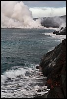 Coast with lava and clouds of smoke and steam produced by lava contact with ocean. Hawaii Volcanoes National Park, Hawaii, USA. (color)