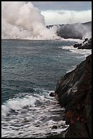 Coast with lava and clouds of smoke and steam produced by lava contact with ocean. Hawaii Volcanoes National Park ( color)