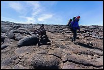 Hiker descending from Mauna Loa summit next to sign. Hawaii Volcanoes National Park, Hawaii, USA. (color)